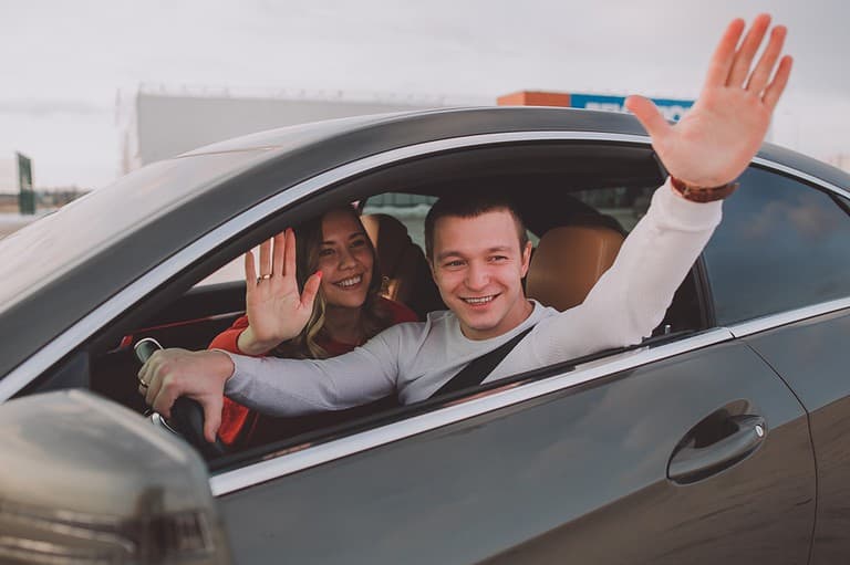 A young couple waves goodbye to their family before they emigrate