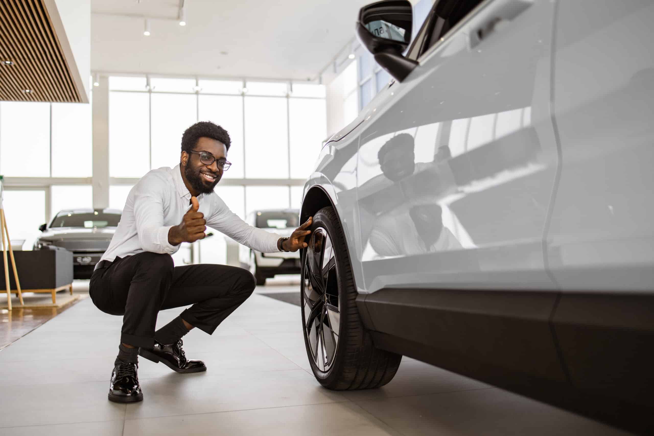 Man examines the rims of a used car for sale
