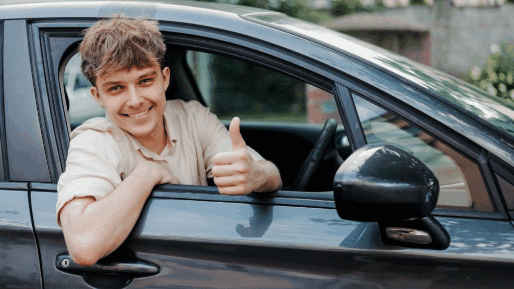 First-time car buyer gives a thumbs-up on his used car purchase