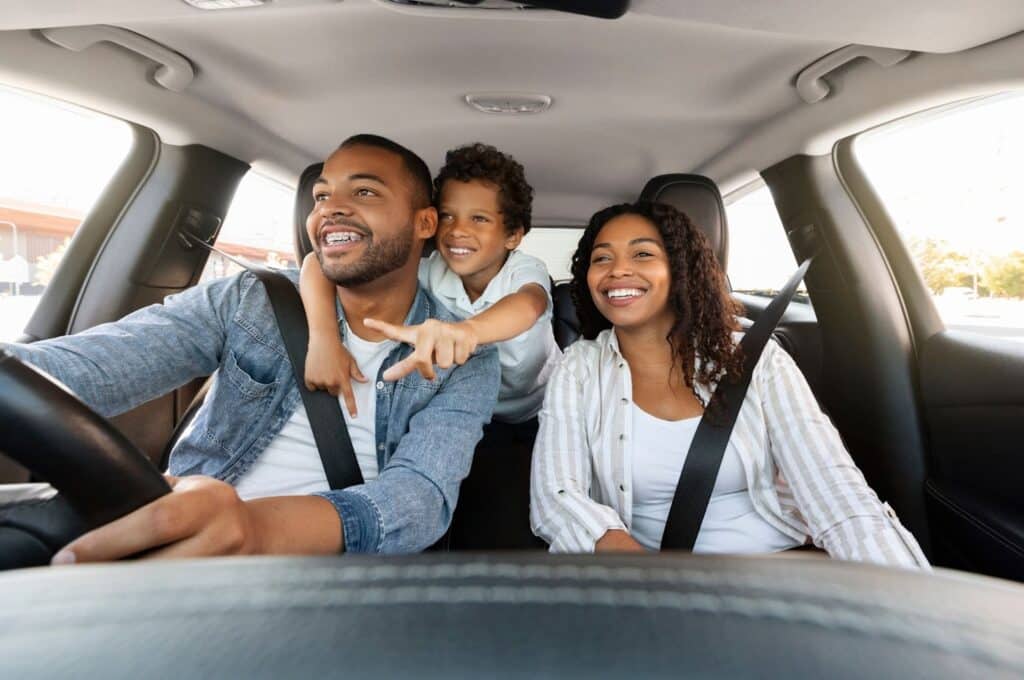 A happy family enjoys a road trip after a successful car service. Is your car ready, or is it time for an online car sale? Get cash when you sell my car online.
